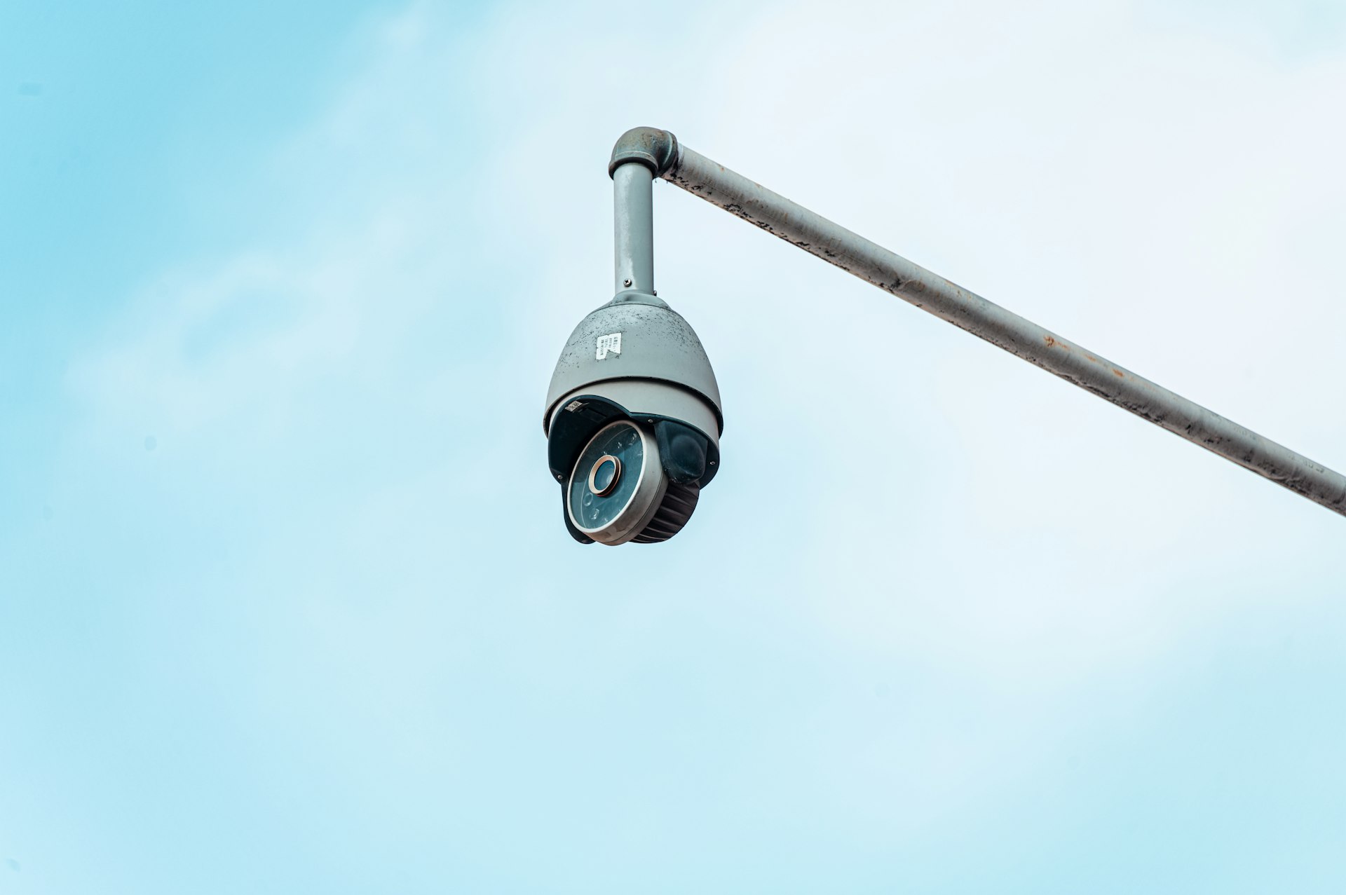 a camera attached to a pole with a sky background